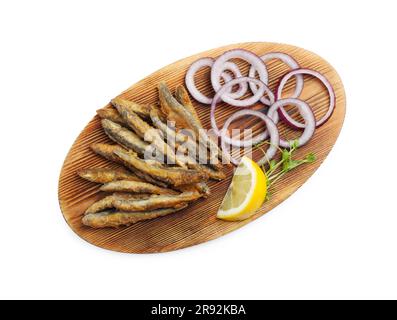 Holzbrett mit köstlichen gebratenen Sardellen, Zitronen- und Zwiebelringen auf weißem Hintergrund, Draufsicht Stockfoto