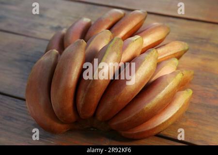 Leckere lila Bananen auf Holztisch, Nahaufnahme Stockfoto