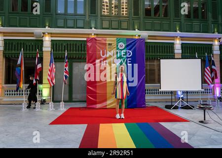 Bangkok, Thailand. 23. Juni 2023. BANGKOK, THAILAND. JUNI 23 - jemand posiert für ein Foto vor einem Regenbogenbanner für das Ereignis „United in Love“ im Haus in Sathorn in Bangkok am 23. Juni 2023. Die britische Botschaft Bangkok und die USA Embassy Bangkok veranstaltet im W Hotel ein jährliches LGBTQIA Pride Event, um die Bemühungen von Menschenrechtsverteidigern zu würdigen, die sich für LGBT-Rechte und -Inklusion einsetzen, und um das Engagement Großbritanniens und der USA für Gleichberechtigung, Gleichstellung und LGBT-Gemeinschaften in Thailand zu bekräftigen. Kredit: Matt Hunt/Neato/Alamy Live News Stockfoto