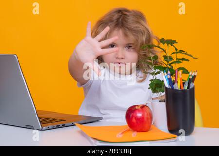 Hör auf, mich zu schikanieren Traurige und wütende Schülerin. Nerd-Schüler aus der Grundschule mit Buch isoliert auf gelbem Studiohintergrund. Intelligente, geniale Intelligenz Stockfoto