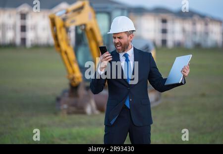 Buider-Mann in Anzug und Schutzhelm. Bauinvestor. Geschäftsmann-Investor vor der Baustelle. Erfolgreicher Investor. Ein hübscher Mann im Anzug Stockfoto