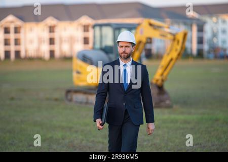 Buider-Mann in Anzug und Schutzhelm. Bauinvestor. Geschäftsmann-Investor vor der Baustelle. Erfolgreicher Investor. Ein hübscher Mann im Anzug Stockfoto