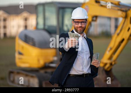Buider-Mann in Anzug und Schutzhelm. Bauinvestor. Geschäftsmann-Investor vor der Baustelle. Erfolgreicher Investor. Ein hübscher Mann im Anzug Stockfoto
