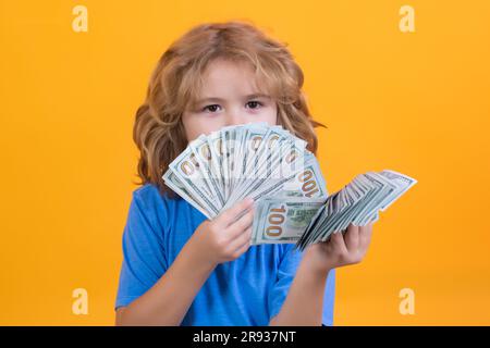 Der Junge hat viele hundert Dollar isoliert auf gelbem Hintergrund. Stockfoto