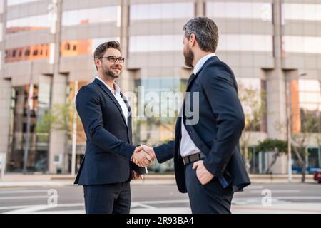 Das Bild von zwei Geschäftsleuten, die mit Handschlag zu tun haben. Zwei Geschäftsmänner geben sich die Hand. Stockfoto