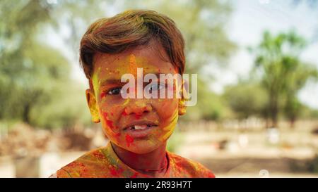 Porträt von Little Boy, der mit Farben spielt. Holi-Konzept. Kind bedeckt mit farbigem Pulver während des Farbenfestes in Rajasthan Stockfoto