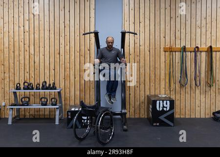 (230624) -- ATHEN, 24. Juni 2023 (Xinhua) -- George Sfaltos trainiert in einem Fitnesscenter in Athen, Griechenland, 7. März 2023. Ein maßgeschneiderter Sit-Ski-Rollstuhl, gespendet vom Piraeus Container Terminal (PCT) in Griechenland, einer Tochtergesellschaft von COSCO Shipping in China, hilft dem Alpinskiläufer George Sfaltos, seinen Traum von der Teilnahme an den Paralympischen Winterspielen 2026 in Milano Cortina zu verwirklichen.UND DAZU „Feature: Piräus Container Terminal hilft dem griechischen Paralympischen Athleten, seinen Traum zu verwirklichen“ (Foto: Lefteris Partsalis/Xinhua) Stockfoto