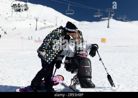 (230624) -- ATHEN, 24. Juni 2023 (Xinhua) -- George Sfaltos (R) küsst seine Frau am 19. Februar 2023 in einem Skigebiet in Mittelgriechenland. Ein maßgeschneiderter Sit-Ski-Rollstuhl, gespendet vom Piraeus Container Terminal (PCT) in Griechenland, einer Tochtergesellschaft von COSCO Shipping in China, hilft dem Alpinskiläufer George Sfaltos, seinen Traum von der Teilnahme an den Paralympischen Winterspielen 2026 in Milano Cortina zu verwirklichen.UND DAZU „Feature: Piräus Container Terminal hilft dem griechischen Paralympischen Athleten, seinen Traum zu verwirklichen“ (Foto: Lefteris Partsalis/Xinhua) Stockfoto