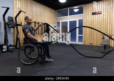 (230624) -- ATHEN, 24. Juni 2023 (Xinhua) -- George Sfaltos trainiert in einem Fitnesscenter in Athen, Griechenland, 7. März 2023. Ein maßgeschneiderter Sit-Ski-Rollstuhl, der vom Piraeus Container Terminal (PCT) in Griechenland, einer Tochtergesellschaft der chinesischen COSCO Shipping, gespendet wird, hilft dem Alpinskifahrer George Sfaltos, seinen Traum von der Teilnahme an den Paralympischen Winterspielen 2026 in Milano Cortina zu verwirklichen. PASSEND zu „Feature: Piraeus Container Terminal hilft dem griechischen Paralympischen Athleten, seinen Traum zu verwirklichen“ (Foto: Lefteris Partsalis/Xinhua) Stockfoto