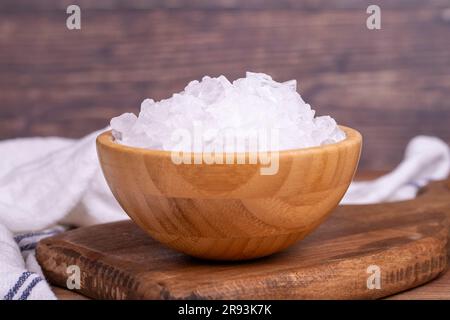 Zitronensalz oder Zitronensäure auf Holzhintergrund. Zitronensäure oder Zitronensalz in einer Holzschüssel Stockfoto