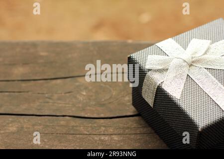 Verschiedene Geschenkschachteln mit Sonnenlicht auf dem Rasen des Parks an einem sonnigen Sommertag:Schachtel für Geschenk mit goldenem Band auf dem Holztisch Stockfoto