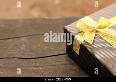 Verschiedene Geschenkschachteln mit Sonnenlicht auf dem Rasen des Parks an einem sonnigen Sommertag:Schachtel für Geschenk mit goldenem Band auf dem Holztisch Stockfoto