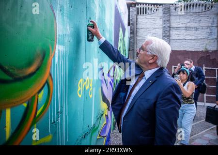 22. Juni 2023, Kirgisistan, Bischkek: Deutscher Präsident Frank-Walter Steinmeier besucht die Künstlergruppe Basicolors und sprüht eine bunte Blume auf die Graffiti-Wand. Kirgisische und deutsche Graffiti-Künstler entwerfen das Kunstprojekt. Neben politischen Gesprächen umfasst der zweitägige Staatsbesuch in Kirgisistan auch Treffen mit Studenten, einen Besuch einer Glasfabrik und eine Tour durch den Ala Archa Nationalpark. Foto: Jens Büttner/dpa Stockfoto