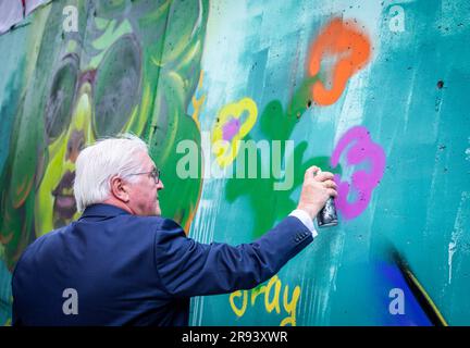 22. Juni 2023, Kirgisistan, Bischkek: Deutscher Präsident Frank-Walter Steinmeier besucht die Künstlergruppe Basicolors und sprüht eine bunte Blume auf die Graffiti-Wand. Kirgisische und deutsche Graffiti-Künstler entwerfen das Kunstprojekt. Neben politischen Gesprächen umfasst der zweitägige Staatsbesuch in Kirgisistan auch Treffen mit Studenten, einen Besuch einer Glasfabrik und eine Tour durch den Ala Archa Nationalpark. Foto: Jens Büttner/dpa Stockfoto