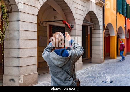 Padua, Italien - 4. April 2022: Junger Besucher macht Fotos in den historischen Straßen von Padua, Veneto, Italien. Stockfoto