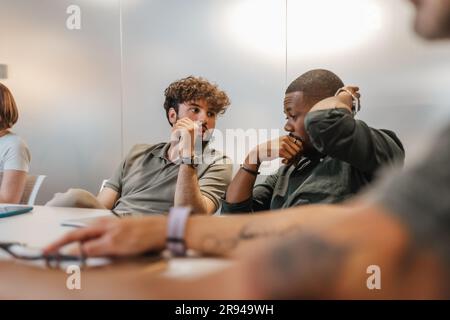 Multirassische Kollegen, die über Geschäfte reden Stockfoto