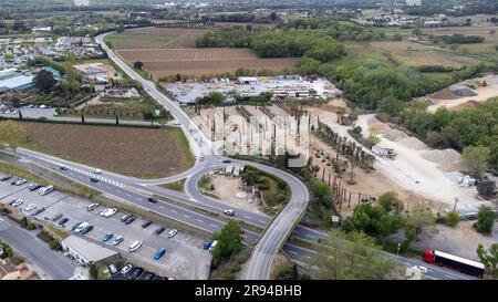 Port Grimaud mit Blick auf die Kulisse mit Baustelle, Gartencenter, Bäumen, Geschäften und Bergen an der Cote d'azur, Französische Riviera, Drohne Stockfoto