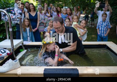 Stuttgart, Deutschland. 24. Juni 2023. Pastor Michel Krimmer von der Kesselkirche tauft die kleine Mathilda beim Tauffestival am Fernsehturm. Kredit: Christoph Schmidt/dpa/Alamy Live News Stockfoto