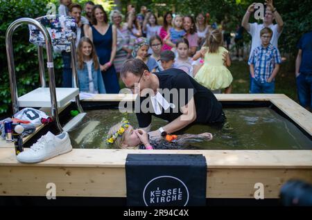 Stuttgart, Deutschland. 24. Juni 2023. Pastor Michel Krimmer von der Kesselkirche tauft die kleine Mathilda beim Tauffestival am Fernsehturm. Kredit: Christoph Schmidt/dpa/Alamy Live News Stockfoto