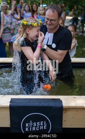 Stuttgart, Deutschland. 24. Juni 2023. Pastor Michel Krimmer von der Kesselkirche tauft die kleine Mathilda beim Tauffestival am Fernsehturm. Kredit: Christoph Schmidt/dpa/Alamy Live News Stockfoto