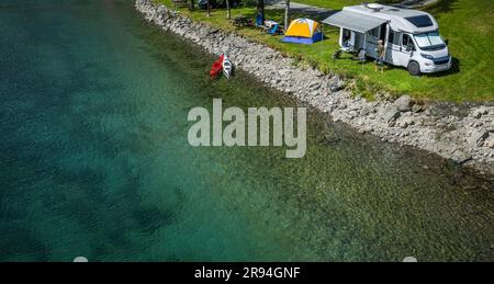 Luftaufnahme eines Wohnmobilparks am Wasser. Wohnmobil und ein Zelt neben dem Crystal Clear Glacial River Stockfoto