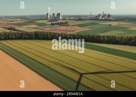 Drohnenansicht des Windmühlenschattens und des Kohlekraftwerks Neurath im Hintergrund von Grevenbroich Stockfoto