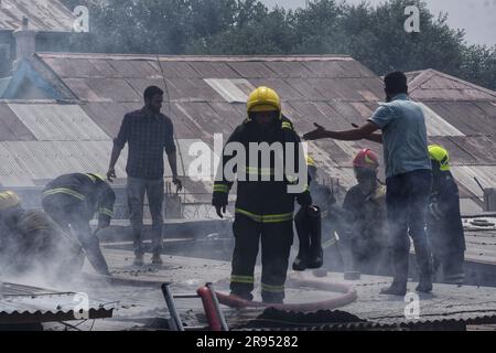 Srinagar, Indien. 24. Juni 2023. Am 24. Juni 2023 arbeiten Feuerwehrleute zusammen mit den Einheimischen daran, ein Feuer in einem Einkaufszentrum in Srinagar zu löschen. (Foto von Mubashir Hassan/Pacific Press) Kredit: Pacific Press Media Production Corp./Alamy Live News Stockfoto