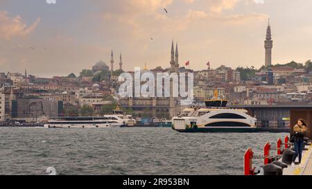 Istanbul, Türkei - 5. Mai 2023: Blick auf die Skyline von Istanbul vom Galataport aus mit Blick auf den Fährhafen Karakoy mit angedockter Fähre und Yeni Cami oder die neue Moschee vor Sonnenuntergang Stockfoto