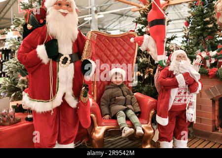 Ein Junge mit Hut besucht den Weihnachtsmann Stockfoto