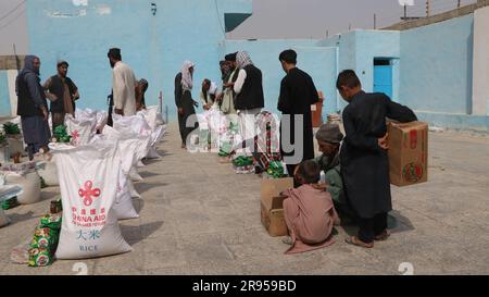 Farah, Afghanistan. 22. Juni 2023. Bedürftige Afghanen erhalten Nahrungsmittelhilfe von China in der Provinz Farah, Afghanistan, am 22. Juni 2023. Die afghanischen Behörden haben am Donnerstag 213 bedürftige Familien in der westlichen Provinz Farah von China gespendete Hilfe erhalten, der Finanz- und Verwaltungsleiter der Provinz Samihullah Tawakali sagte am Freitag. Kredit: Mashal/Xinhua/Alamy Live News Stockfoto