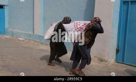 Farah, Afghanistan. 22. Juni 2023. People Carry China-spendete Nahrungsmittelhilfe in Farah Province, Afghanistan, 22. Juni 2023. Die afghanischen Behörden haben am Donnerstag 213 bedürftige Familien in der westlichen Provinz Farah von China gespendete Hilfe erhalten, der Finanz- und Verwaltungsleiter der Provinz Samihullah Tawakali sagte am Freitag. Kredit: Mashal/Xinhua/Alamy Live News Stockfoto