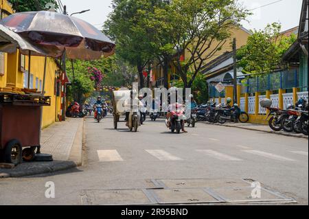 Das Moped ist das am weitesten verbreitete motorisierte Transportmittel in Vietnam. Hier fahren sie durch die Straßen der Altstadt von Hoi an. Stockfoto