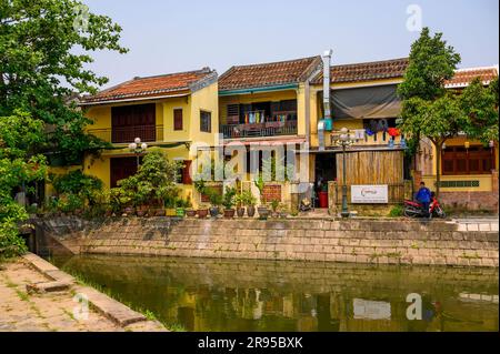 Ein Teich mit einer Reihe traditioneller Häuser am Ufer in der Altstadt von Hoi an, Vietnam. Stockfoto