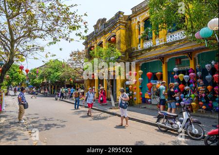 Eine typische Straßenszene mit den charakteristischen bunten Papierlaternen und Touristen, die in Hoi an, Vietnam, herumlaufen. Stockfoto