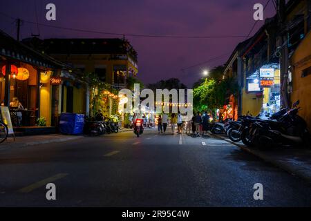 Einheimische und Touristen gehen bei Nacht in die Straßen der Altstadt von Hoi an mit den vielen bunten Lichtern und Papierlaternen. Vietnam. Stockfoto