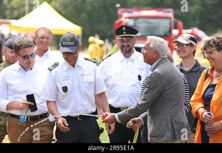 24. Juni 2023, Baden-Württemberg, Külsheim: Thomas Strobl, Innenminister Baden-Württembergs (CDU) hält während einer Feuerübung mit 400 Einsatzkräften in einem Ausbildungsbereich der Bundeswehr einen Feuerwehrschlauch. Foto: Karl-Josef Hildenbrand/dpa Stockfoto