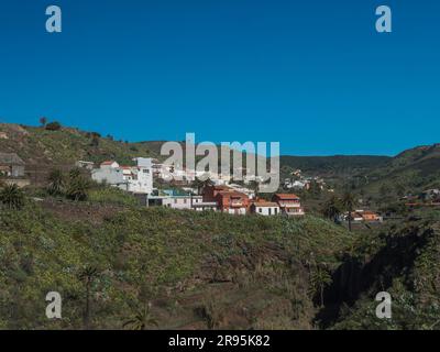 Malerisches Dorf Vallehermoso mit seinen bunten Häusern, Bergen, Palmen und Terrassenfeldern. La Gomera, Kanarische Inseln, Spanien Stockfoto