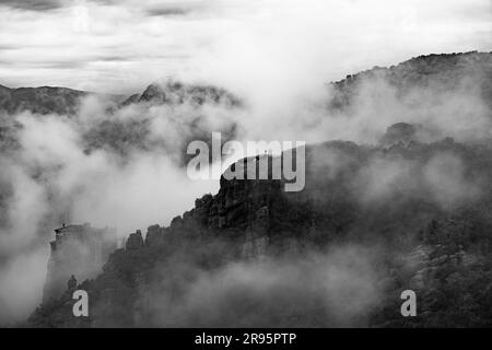 Meteora-Klosteranlage, Griechenland. Orthodoxes Kloster auf dem Felsen, das aus dem Morgennebel auftaucht, UNESCO-Weltkulturerbe, Griechenland. Stockfoto
