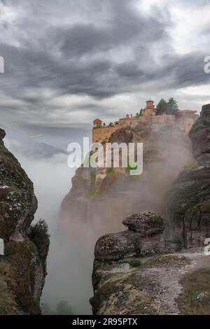 Meteora-Klosteranlage, Griechenland. Orthodoxes Kloster auf dem Felsen, das aus dem Morgennebel auftaucht, UNESCO-Weltkulturerbe, Griechenland. Stockfoto