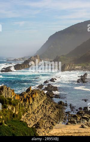 Eine kleine geschützte Bucht, versteckt zwischen den hohen Klippen und Felsen der Küste von Tsitsikamma, entlang der südlichen südafrikanischen Küste. Stockfoto