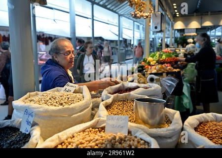 Verkäufer, der eine Vielzahl von trockenen Bohnen sowie Obst und Gemüse auf dem Bolho-Markt verkauft, mit Kundenauswahl, Porto, Portugal Stockfoto