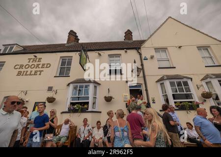 Leigh on Sea, Großbritannien. Juni 2023. Eine lebhafte Menschenmenge genießt Drinks und Gespräche vor dem Crooked Billet, einem traditionellen britischen Pub in Leigh-on-Sea, Essex. Das cremefarbene Gebäude ist mit hängenden Blumenkörben und Schildern unter einem bewölkten Himmel geschmückt. Die Szene fängt den Gemeinschaftsgeist und die Freizeit an der Küste ein. Die Leute draußen in Old Leigh auf dem Meer genießen das heiße Wetter. Penelope Barritt/Alamy Live News Stockfoto