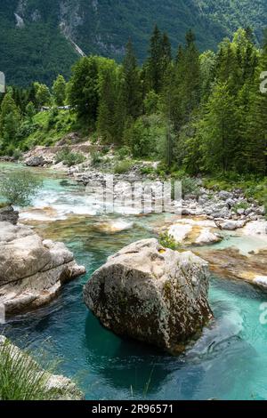 Soca Valley: Die strahlende Gelassenheit der Sonne, goldenes Leuchten auf einem schnell fließenden Fluss. Türkisfarbenes Wasser reflektiert tanzendes Sonnenlicht und faszinierende Wandteppiche. Stockfoto