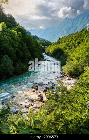 Soca Valley: Die strahlende Gelassenheit der Sonne, goldenes Leuchten auf einem schnell fließenden Fluss. Türkisfarbenes Wasser reflektiert tanzendes Sonnenlicht und erzeugt faszinierende Tapeten. Stockfoto