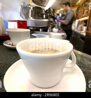 Eine fesselnde Nahaufnahme eines frisch gebrühten Americano-Kaffees, zubereitet in einem italienischen Café. Das Bild zeigt einen perfekt gegossenen Kaffee in einem Styl Stockfoto