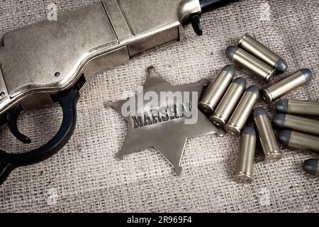 Old-West-Marshal-Abzeichen mit Munition-Hintergrund Stockfoto