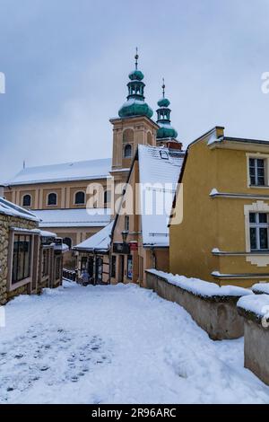 Klodzko, Polen - Januar 2023: Kleine gotische Brücke über den Fluss Mlynowka im Stadtzentrum und im Winter von frischem Schnee bedeckt Stockfoto