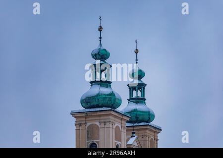Klodzko, Polen - Januar 2023: Zwei Bronzetürme mit Kreuzen auf dem Franziskanerkloster im Stadtzentrum Stockfoto
