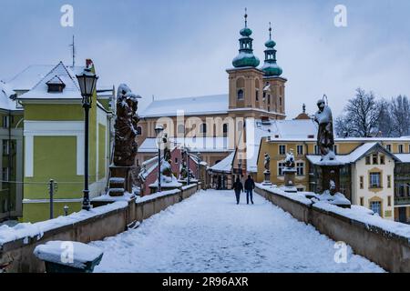 Klodzko, Polen - Januar 2023: Kleine gotische Brücke über den Fluss Mlynowka im Stadtzentrum und im Winter von frischem Schnee bedeckt Stockfoto