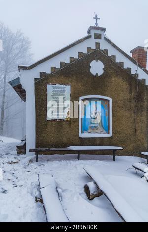 Bardo, Polen - Januar 2023: Bergkapelle unserer Lieben Frau des Weinens in den Bardo-Bergen voller Schnee und Nebel im Winter Stockfoto